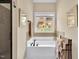 Bright bathroom featuring a soaking tub with black fixtures and a view of the outdoors at 181 Fawn Hill Ct, Garner, NC 27529