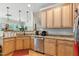 Functional kitchen featuring granite countertops, stainless steel appliances, and natural wood cabinets at 181 Fawn Hill Ct, Garner, NC 27529