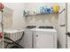 Functional laundry room featuring a modern washer and dryer with storage shelving and a laundry cart at 181 Fawn Hill Ct, Garner, NC 27529