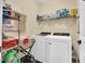 Laundry room equipped with modern washer and dryer, storage shelves, and cleaning supplies at 181 Fawn Hill Ct, Garner, NC 27529