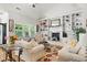 Bright living room with built-in shelves, a cozy fireplace, and large windows at 181 Fawn Hill Ct, Garner, NC 27529