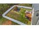 Aerial view of backyard with play set, patio set, and wooden deck enclosed by a white wooden fence at 189 Grey Hawk Dr, Garner, NC 27529