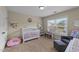 The charming Bedroom includes a crib, chair, and large window for natural light at 189 Grey Hawk Dr, Garner, NC 27529