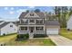 Charming two-story home features a covered front porch, manicured lawn, and a two-car garage at 189 Grey Hawk Dr, Garner, NC 27529