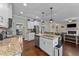 Bright kitchen featuring granite counters, stainless steel appliances, a center island with seating, and hardwood floors at 189 Grey Hawk Dr, Garner, NC 27529