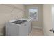 Well-lit laundry room featuring a front-load washer and dryer, a bright window, and wire shelving at 189 Grey Hawk Dr, Garner, NC 27529