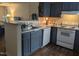 Well-lit kitchen with stainless steel appliances, dark cabinetry, and wood flooring at 1911 Wolftech Ln # 204, Raleigh, NC 27603