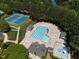 Stunning aerial view of the community pool and tennis courts surrounded by lush greenery and mature trees at 192 Solheim Ln, Raleigh, NC 27603