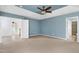 Bright main bedroom with a blue tray ceiling, ceiling fan, carpet flooring, and ensuite bathroom access at 192 Solheim Ln, Raleigh, NC 27603