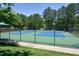 Well-maintained community tennis courts with green and blue surface surrounded by trees at 192 Solheim Ln, Raleigh, NC 27603