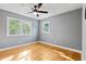 Bright bedroom featuring beautiful hardwood floors, modern fan, and large, sun-filled windows at 204 N Gurney St, Burlington, NC 27215