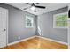 This simple bedroom includes hardwood floors, a modern fan, and bright windows at 204 N Gurney St, Burlington, NC 27215