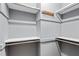 Walk-in closet featuring built-in shelving, hanging rods, and neutral walls at 204 N Gurney St, Burlington, NC 27215