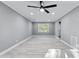 Spacious living room with modern ceiling fan, new floors, fresh gray paint, and large windows at 204 N Gurney St, Burlington, NC 27215