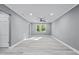 Large living room featuring modern ceiling fan, fresh gray paint, new floors and a bright window at 204 N Gurney St, Burlington, NC 27215
