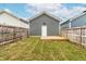 Backyard features a detached garage with string lights and a small wooden deck and newly installed wooden fence at 221 Douglas Falls Dr, Wendell, NC 27591