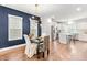 Elegant dining room with modern light fixture and views into the bright, white kitchen at 221 Douglas Falls Dr, Wendell, NC 27591