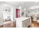 Open kitchen area with a center island with seating, white cabinets, and views into other living spaces at 221 Douglas Falls Dr, Wendell, NC 27591