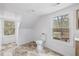 Well-lit attic bathroom with tile floors, dormer windows, and a modern toilet at 226 1St St, Henderson, NC 27536