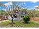 Charming home featuring a well-maintained front yard with mature trees, a picket fence, and inviting curb appeal at 226 1St St, Henderson, NC 27536