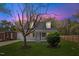 Charming home featuring a well-maintained front yard with mature trees, a picket fence, during a vibrant sunset at 226 1St St, Henderson, NC 27536