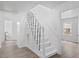 Well-lit staircase featuring white stairs, black metal railings, and wood-look floors at 226 1St St, Henderson, NC 27536