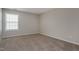 Well-lit bedroom features a window with blinds and neutral carpeting at 2321 Stony Bottom Dr, Raleigh, NC 27610