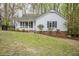 Charming single-story home with white siding and a welcoming front porch nestled among mature trees at 2400 Hemlock Cir, Clayton, NC 27520