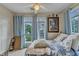 Bright bedroom with windows, cozy bedding, and artwork at 2521 Friedland Pl # 201, Raleigh, NC 27617