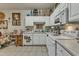 Bright kitchen featuring white cabinetry, appliances, and tile flooring at 2521 Friedland Pl # 201, Raleigh, NC 27617
