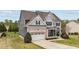 Charming two-story home featuring a brick and siding exterior, attached garage, and well-manicured landscaping at 265 Beckwith Ave, Clayton, NC 27527