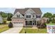 Charming two-story home featuring a brick and siding exterior, attached garage, and well-manicured landscaping at 265 Beckwith Ave, Clayton, NC 27527