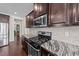 Close-up of the kitchen featuring dark cabinetry, stainless steel appliances and granite countertops at 265 Beckwith Ave, Clayton, NC 27527