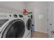 Bright laundry room featuring a front loading washer and dryer, overhead shelving, and ample storage space at 265 Beckwith Ave, Clayton, NC 27527
