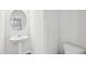 Bathroom with pedestal sink, toilet, hardwood floors, and a decorative mirror at 272 Hiking Hill Ln, Garner, NC 27529