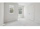 Well-lit bedroom with carpeted floor, two windows, and neutral decor at 272 Hiking Hill Ln, Garner, NC 27529