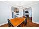 View of open dining and living rooms with hardwood floors. Kitchen in background features updated appliances at 2724 N Roxboro St, Durham, NC 27704
