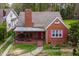 Beautiful red brick home with covered front porch and pink window shutters at 2724 N Roxboro St, Durham, NC 27704