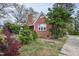 Charming red brick home featuring a covered front porch and colorful landscaping at 2724 N Roxboro St, Durham, NC 27704