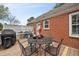 Back patio with a dining set, brick exterior, and privacy screen at 2724 N Roxboro St, Durham, NC 27704