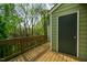 A home features a balcony complete with wood flooring, green sidings, and a door that leads inside at 308 Cedarwood Ln, Carrboro, NC 27510