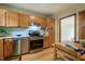 Well-lit kitchen with stainless steel oven, wooden cabinets, and dining table at 308 Cedarwood Ln, Carrboro, NC 27510