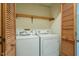 A laundry room features a washer and dryer, as well as wooden shelving and closet with doors at 308 Cedarwood Ln, Carrboro, NC 27510