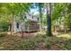 Exterior view of the home featuring a screened porch and a wooded backyard at 3421 E Jameson Rd, Raleigh, NC 27604