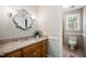 Bathroom featuring granite countertops, warm wood cabinetry, and stylish lighting at 3421 E Jameson Rd, Raleigh, NC 27604