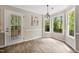 Cozy dining area with bay windows, wood-look floors, and a decorative light fixture at 3421 E Jameson Rd, Raleigh, NC 27604