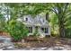 Charming home featuring dormer windows, white siding, mature trees, and a cozy front porch at 3421 E Jameson Rd, Raleigh, NC 27604