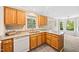 Functional kitchen featuring wood cabinetry, stainless sink, granite counters, and natural light at 3421 E Jameson Rd, Raleigh, NC 27604