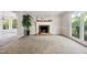 Bright living room with a cozy brick fireplace, neutral paint, and carpeted flooring at 3421 E Jameson Rd, Raleigh, NC 27604