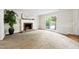Spacious living room with a brick fireplace, large window, and a classic neutral color scheme at 3421 E Jameson Rd, Raleigh, NC 27604